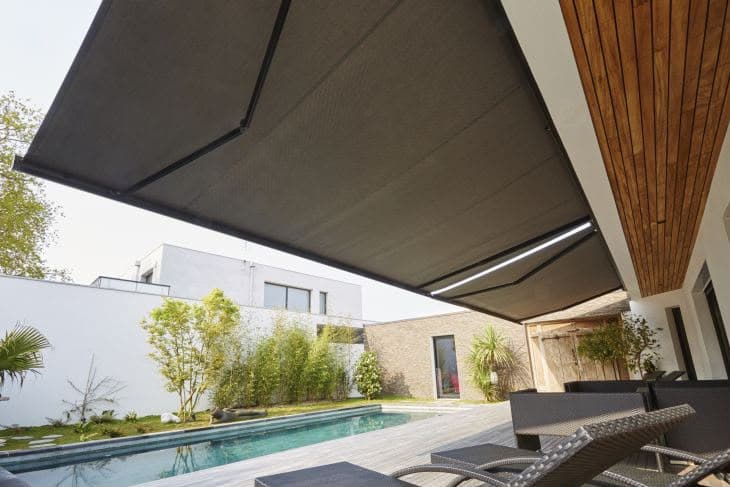 Store banne gris sur terrasse avec piscine